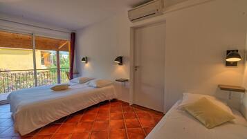 Een hotelkamer met twee bedden, een balkon, een airconditioning en een deur.