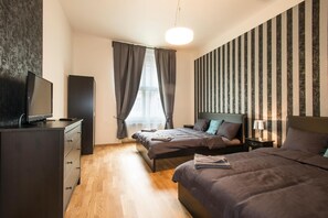A modern bedroom with a bed, bedside tables, a dresser, and a television. - Neklanova Apartments (Prague)