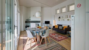 Ein zeitgemäßer Wohnbereich mit Essplatz, einer Couch und einem Fernseher.