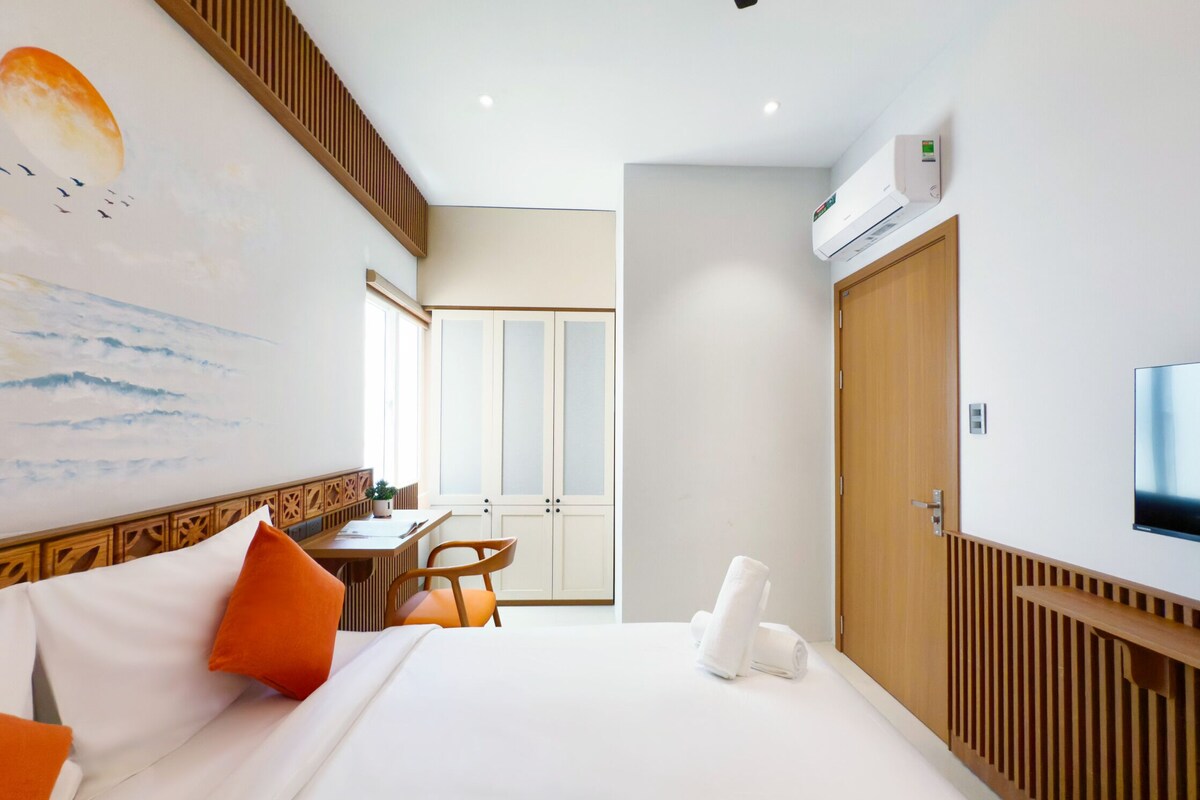 Une chambre d’hôtel équipée d’un lit, d’un bureau, d’une chaise, d’une télévision et d’un appareil de climatisation.