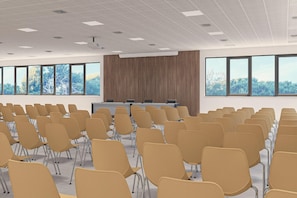 A conference room with rows of chairs, a podium, and large windows. - Eraora Hotel Village (Battipaglia)