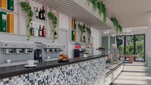 A modern kitchen with a tiled backsplash, coffee machines, and shelves with bottles and plants. - Eraora Hotel Village (Battipaglia)