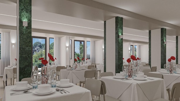 A dining area with multiple tables set for service, large windows, and a view of greenery outside. - Eraora Hotel Village (Battipaglia)