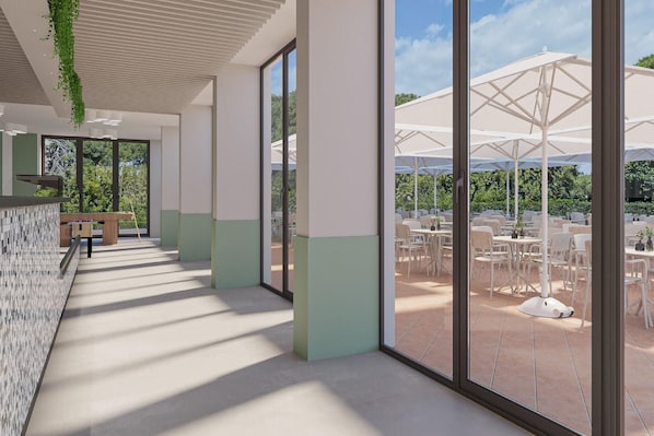 A corridor with a tiled floor, large windows, and a view of an outdoor patio area with umbrellas and tables. - Eraora Hotel Village (Battipaglia)