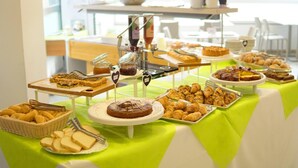 Una mesa de buffet con distintos alimentos y utensilios de servicio.