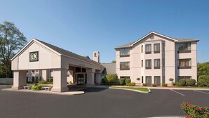 A two-story building with a covered entrance and a parking lot. - Larkspur Landing Hotel South Bend (South Bend)
