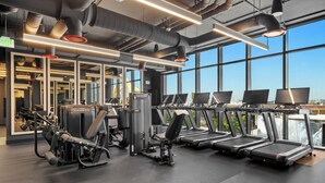 A gym with treadmills, weight machines, and mirrors. - The E11EVEN Hotel & Residences (Miami)
