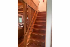 Eine Holztreppe mit Handlauf, die zu einer oberen Etage führt.
