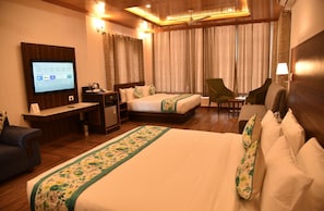A hotel room with a bed, a desk, a chair, a television, and curtains. - Mastiff Wildcrest Dharamshala by Othpl (Palampur)