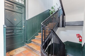 Una escalera con una puerta verde y un extintor en la pared.