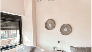 A bedroom with two beds, a wooden ceiling, a hanging light fixture, and two wall-mounted decorative plates. - Lujoso amplio dpto para 8 en Salta con cochera (Salta)