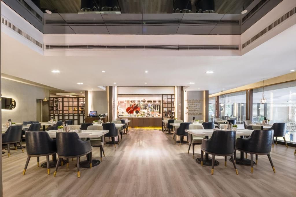 Um restaurante espaçoso com pé direito alto, iluminação moderna e um balcão central com um amplo display.