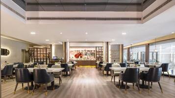 Um restaurante espaçoso com pé direito alto, iluminação moderna e um balcão central com um amplo display.