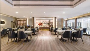 A spacious restaurant with high ceilings, modern lighting, and a central counter with a large display. - Grandskylight Shenzhen Dapeng (Shenzhen)