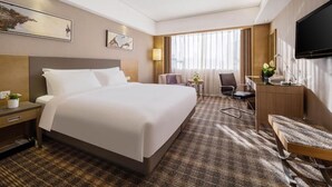 A hotel room with a large bed, a desk, a chair, a television, and artwork on the walls. - Grandskylight Shenzhen Dapeng (Shenzhen)