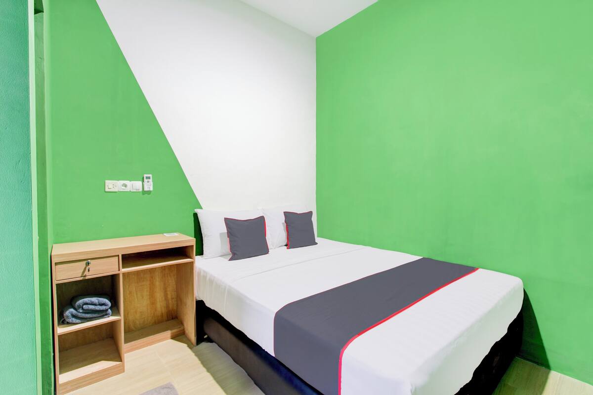 Ein Zimmer mit einem Bett, einem Schreibtisch und einem Regal.