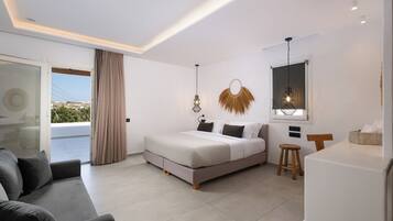 Un dormitorio moderno con cama, sofá, un taburete pequeño, escritorio y vistas a través de un ventanal.