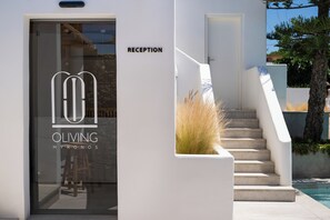 Ein Empfangsbereich mit Glastür, Treppe und Blick auf den Pool.