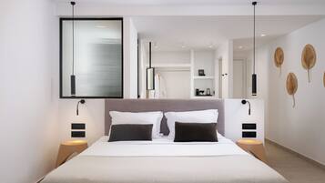 A modern hotel room with a large bed, bedside tables, a wardrobe, and a view of the city.