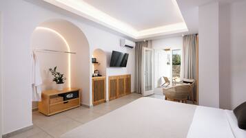 A modern hotel room with a large bed, a TV, a wooden cabinet, a plant, and a balcony with a chair.