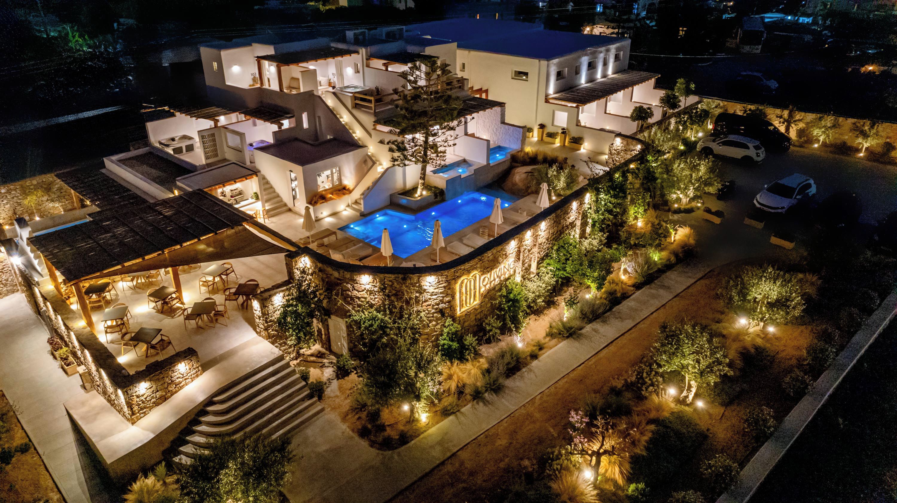 Una casa moderna con piscina, mobiliario de exterior y un jardín bien iluminado.