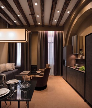 A modern interior with a dining area, a sofa, a chair, and a kitchen with a built-in oven.