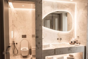 Une salle de bain moderne avec un meuble-lavabo en marbre, des toilettes et un lavabo.