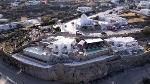 Un hôtel situé sur la côte, composé de plusieurs bâtiments, avec une cour centrale et une piscine.