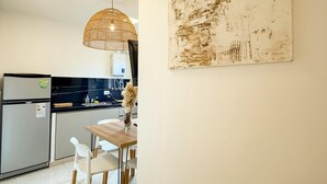 Una cocina moderna con comedor, que incluye un refrigerador, pileta y luces colgantes.