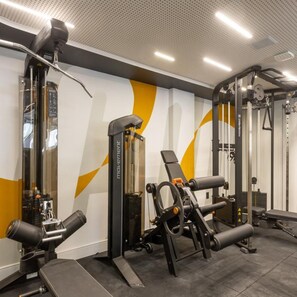A gym with various exercise equipment, including a squat rack, bench press, and cable machine. - Icon Hotel By Welkom (Pitimbu)