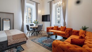 Ein modernes Wohnzimmer mit einer Couch, einem Esstisch und einem Fernseher.
