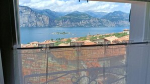 Un balcón con vistas a un lago, montañas y una pequeña isla.