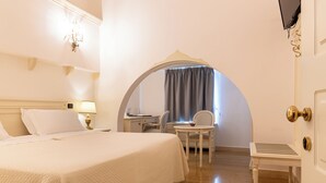 Une chambre d’hôtel avec un lit, un bureau, une chaise et une petite table.