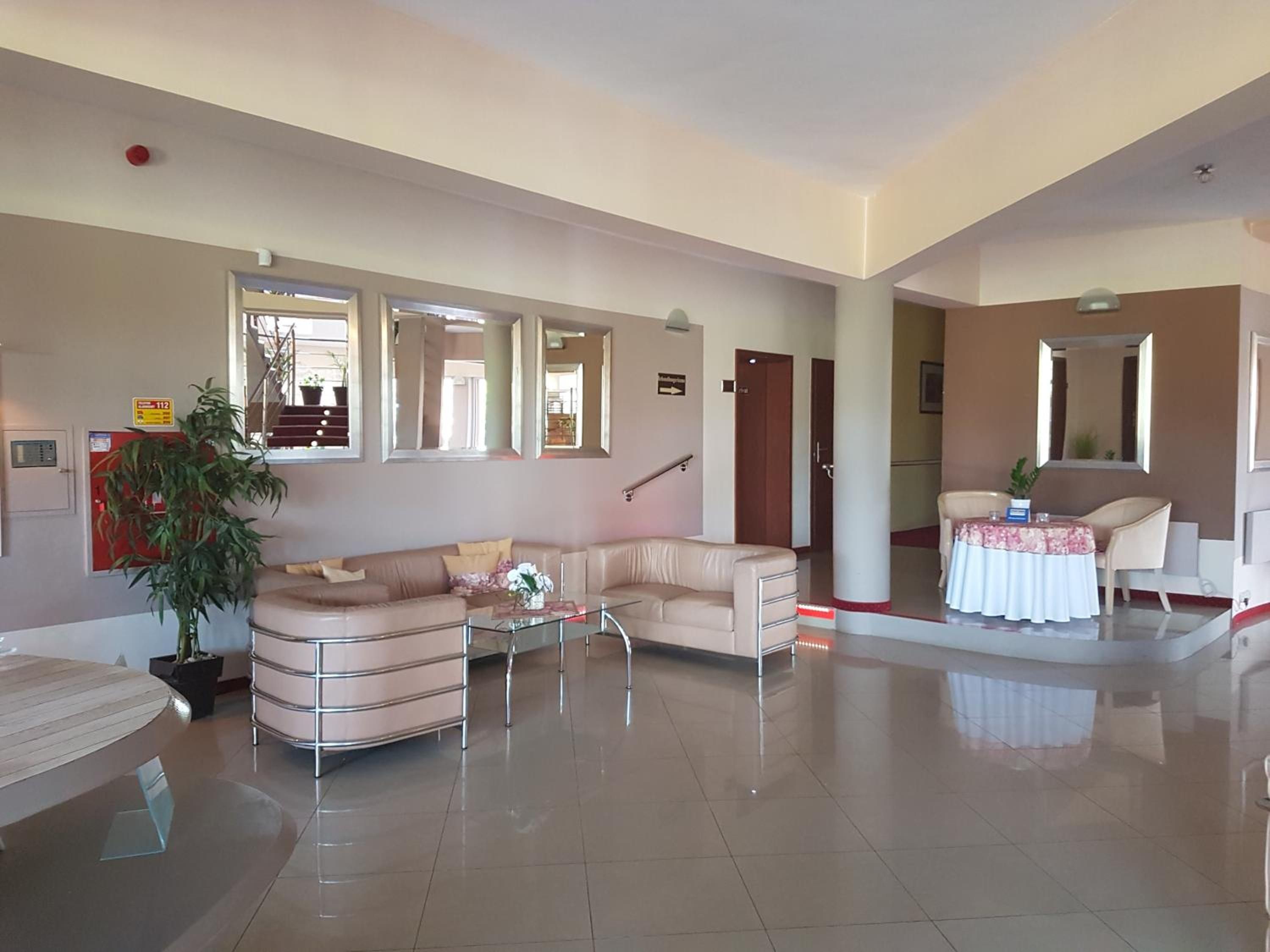 A spacious living area with a sofa, a coffee table, and a dining table set for a small group.