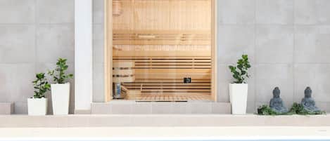 A modern pool area with a wooden sauna door, potted plants, and Buddha statues.