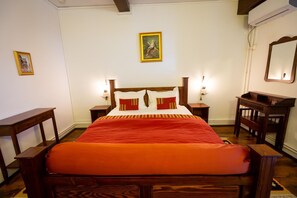 A bedroom with a wooden bed, two bedside tables, a nightstand, a mirror, and a framed picture on the wall. - Complex Turistic Moara Dragaicilor (Mărăcineni)