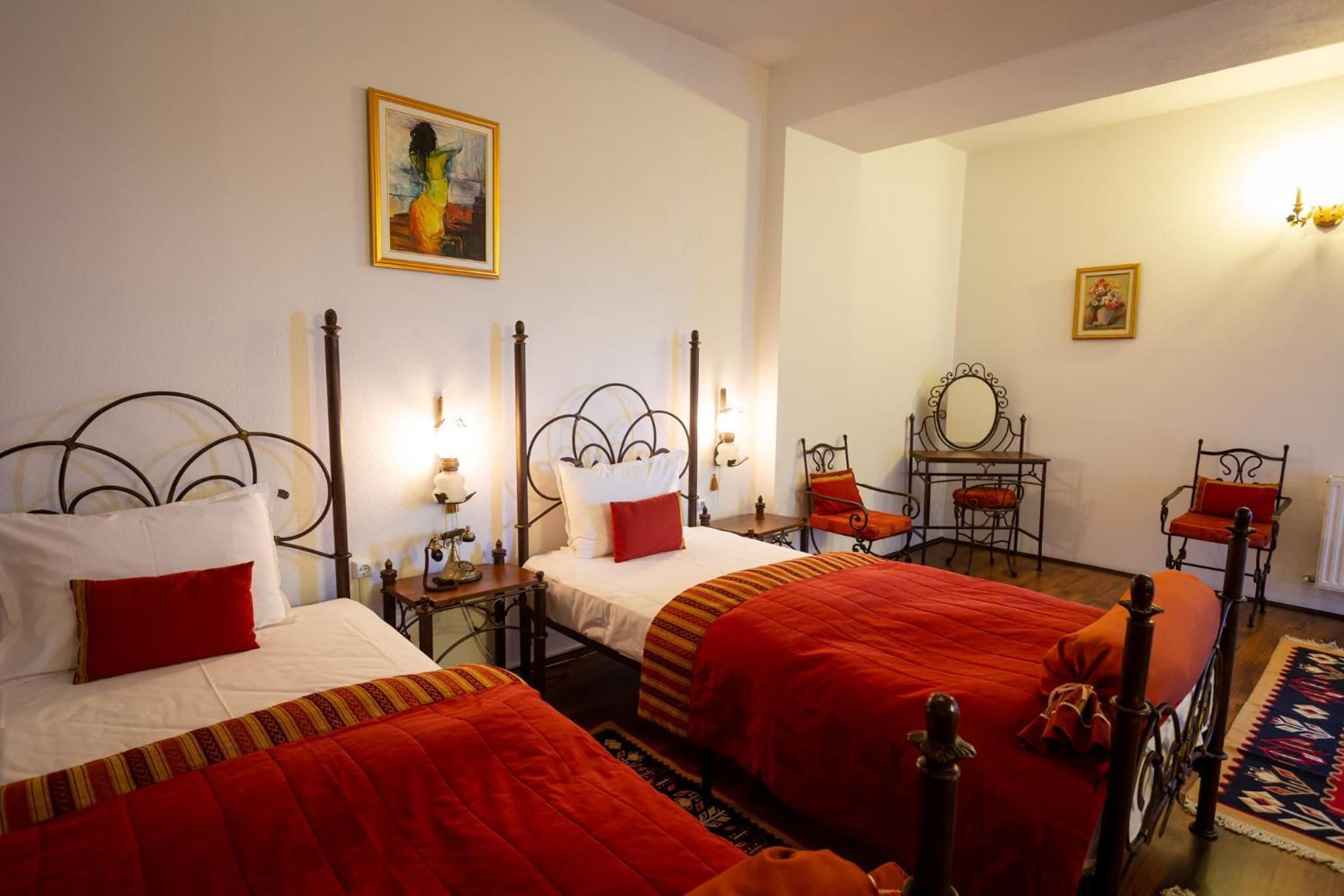 Habitación de hotel con dos camas, una mesita, una silla y un espejo.