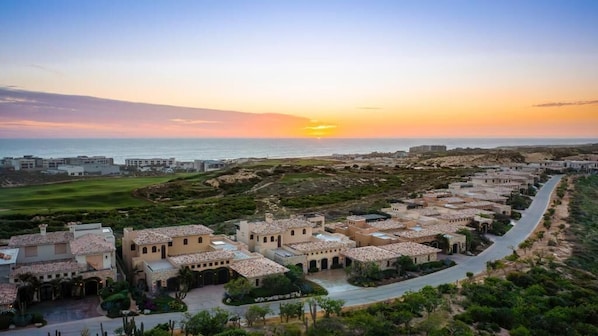 A coastal resort with Mediterranean-style buildings, a paved walkway, and a view of the sea. - The Reserve At Diamante Los Cabos (Cabo San Lucas)