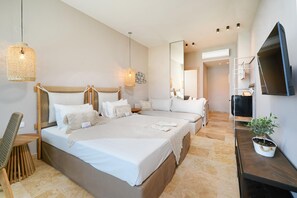 A hotel room with a large bed, a TV, a small table with a plant, and a mirror. - Essentia Luxury (Thasos)