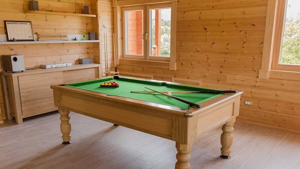 A pool table in a wooden room with a window and shelves. - Transylvania Mountain Chalet (Bran)