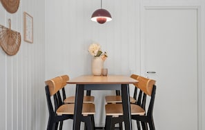 A dining area with a table, chairs, a hanging light fixture, and a wall-mounted decorative item. - Stunning home in Hvide Sande with sauna (Hvide Sande)