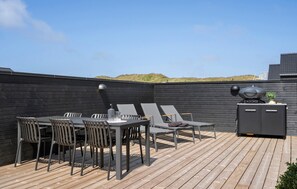 A rooftop patio with a table and chairs, a grill, and a view of the landscape. - Stunning home in Hvide Sande with sauna (Hvide Sande)