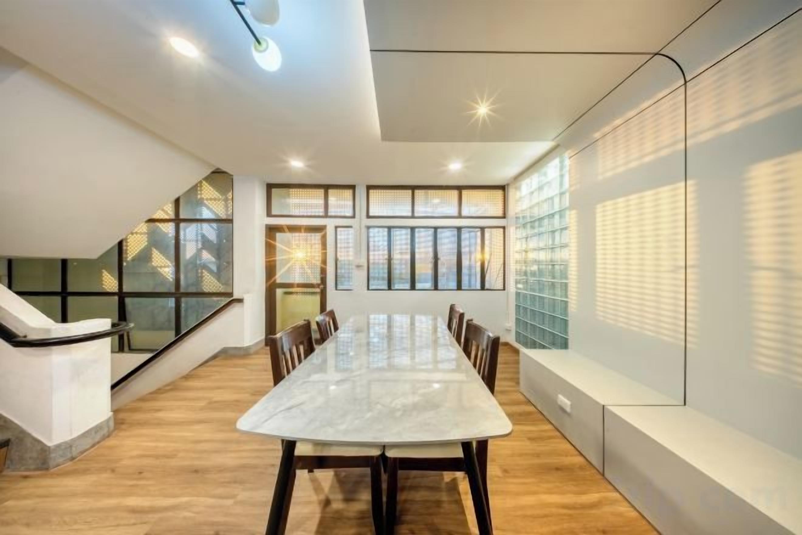 A conference room with a long table, chairs, and a staircase.
