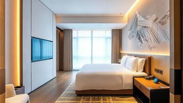 Quarto de hotel moderno com uma cama grande, televisão de tela plana, escrivaninha com cadeira e uma janela ampla com cortinas.