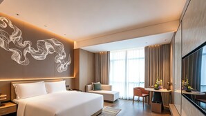 A modern hotel room with a large bed, a sofa, a dining area, and a large window with curtains. - Grand Skylight Hotel Wuhan Optics Valley (Wuhan)