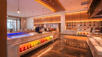 Cozinha moderna com bancadas de mármore, uma ilha central e iluminação pendente.