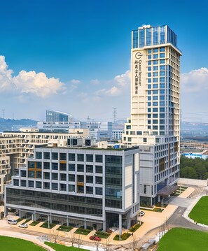 A modern hotel with a prominent tower, a spacious lobby, and a well-maintained outdoor area. - Grand Skylight Hotel Wuhan Optics Valley (Wuhan)
