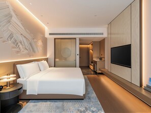 A modern hotel room with a large bed, a flat-screen TV, a desk, and a walk-in closet. - Grand Skylight Hotel Wuhan Optics Valley (Wuhan)
