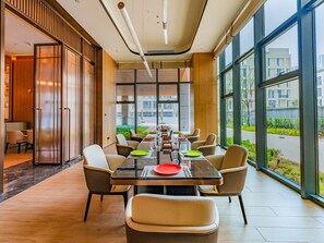 Un comedor moderno con una mesa larga, sillas y vistas al exterior.