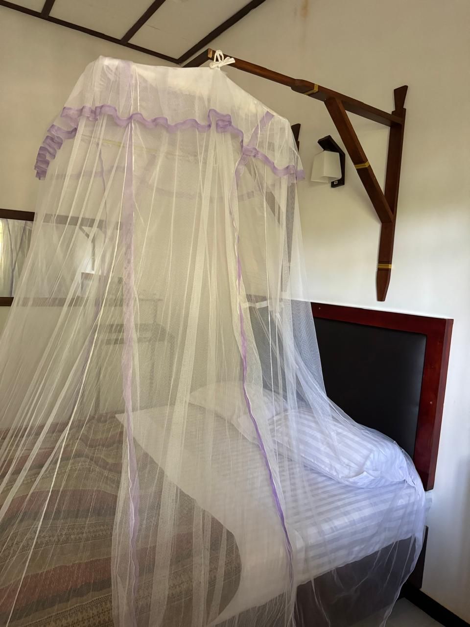 A bed with a white canopy and a wooden headboard.